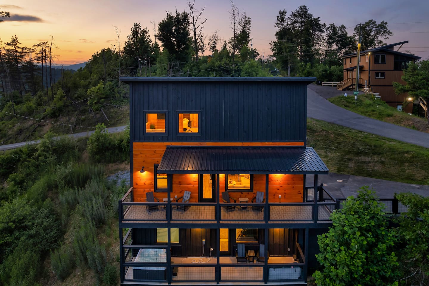 Sugar Splash cabin at dusk with lit decks and outdoor hot tub