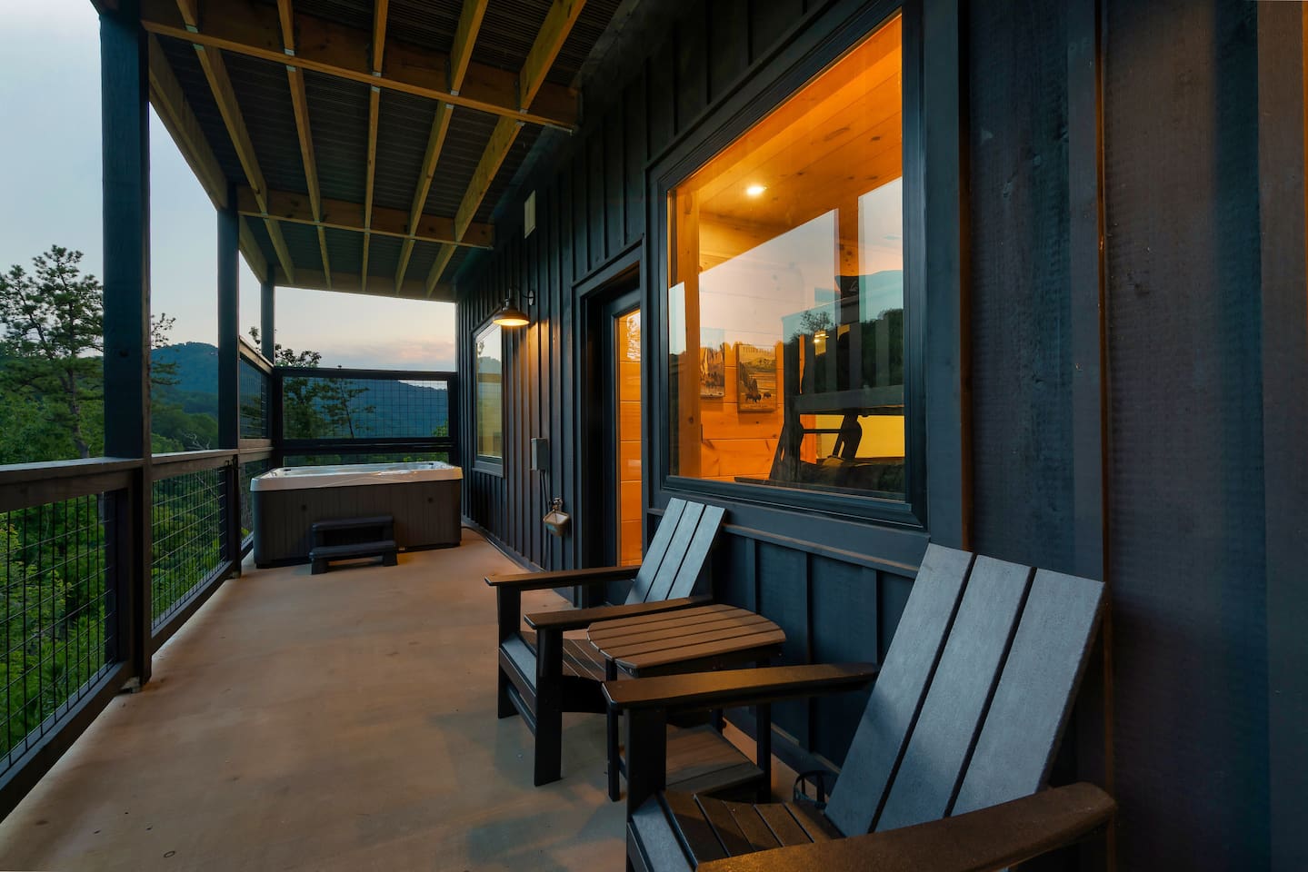 Outdoor hot tub on the cabin deck with mountain forest views